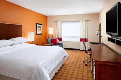 a hotel room with a bed and a flat screen tv at Four Points by Sheraton Edmonton Gateway in Edmonton