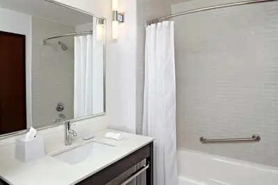 a bathroom with a sink and a shower with a mirror at Four Points by Sheraton Edmonton Gateway in Edmonton