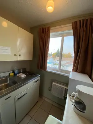 a small kitchen with a sink and a window at Aspen Motor Inn in Drayton Valley