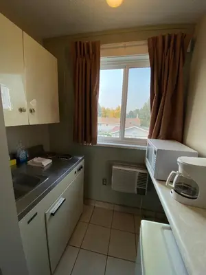 a small kitchen with a sink and a window at Aspen Motor Inn in Drayton Valley