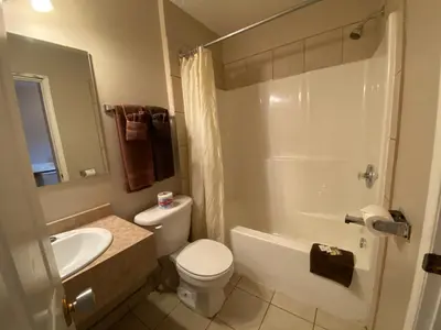 a bathroom with a white toilet and a sink at Aspen Motor Inn in Drayton Valley