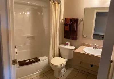 a bathroom with a toilet and a sink at Aspen Motor Inn in Drayton Valley