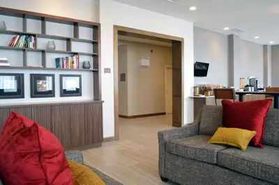 a living room with a couch and a book shelf at Staybridge Suites - Red Deer North by IHG in Red Deer
