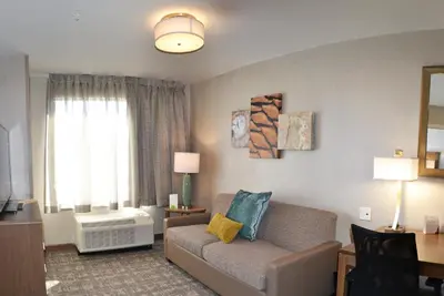 a living room with a couch and a window at Staybridge Suites - Red Deer North by IHG in Red Deer