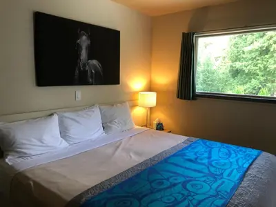 a bedroom with a bed with a horse picture on the wall at The Hitching Post Motel in Pemberton