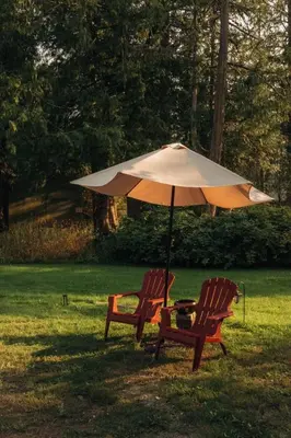 two chairs and an umbrella in the grass at The Hitching Post Motel in Pemberton