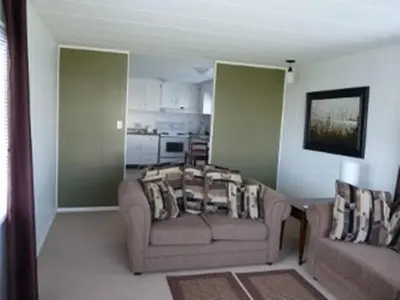 a living room with a couch and a chair at Driftwood by the Sea Inn in Campbell River