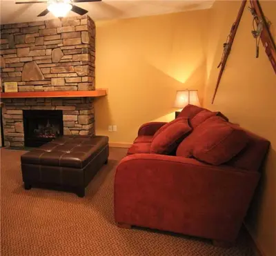 a living room with a red couch and a fireplace at Pinnacle Ridge Chalets by Fernie Lodging Co in Fernie