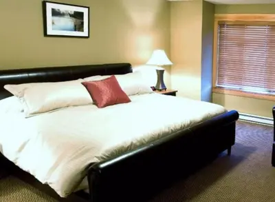 a bedroom with a large white bed with a red pillow at Pinnacle Ridge Chalets by Fernie Lodging Co in Fernie