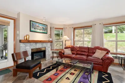 a living room with a leather couch and a fireplace at The Aspens by Whistler Premier in Whistler