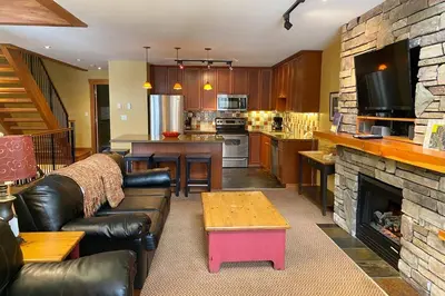 a living room with a couch and a fireplace at Pinnacle Ridge Condos by Fernie Central Reservations in Fernie