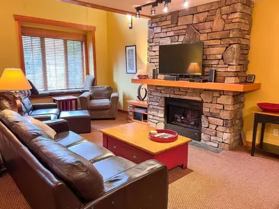 a living room with a couch and a fireplace at Pinnacle Ridge Condos by Fernie Central Reservations in Fernie