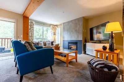 a living room with a blue couch and a fireplace at Ski In & 15 Minute Walk to the Lifts Hot Tub AC Pet Friendly in Fernie