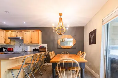 a kitchen with a wooden table and chairs at Ski In & 15 Minute Walk to the Lifts Hot Tub AC Pet Friendly in Fernie