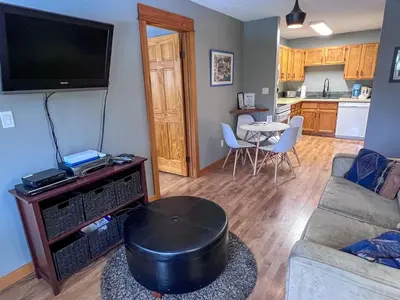 a living room with a couch and a flat screen tv at Griz Inn by Fernie Central Reservations - Right on The Slopes in Fernie