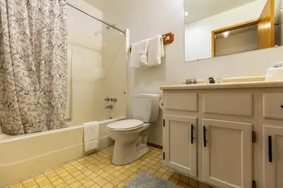 a bathroom with a toilet and a sink and a shower at Griz Inn by Fernie Central Reservations - Right on The Slopes in Fernie