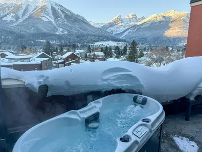 a bath tub covered in snow with a view of mountains at Luxurious 901 Condos by Fernie Central Reservations in Fernie