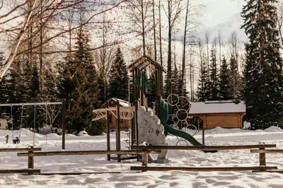 a playground with a slide in the snow at Riverside Resort in Whistler