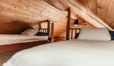 a bedroom with two beds in a wooden cabin at Riverside Resort in Whistler