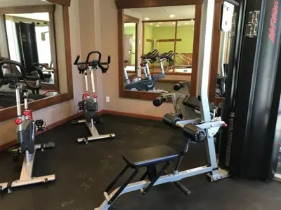 a gym with several exercise bikes and mirrors at Studio suite located in the heart of Whistler village in Whistler