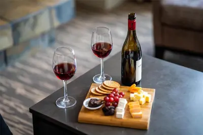 a table with two glasses of wine and cheese and crackers at Hilton Whistler Resort & Spa in Whistler