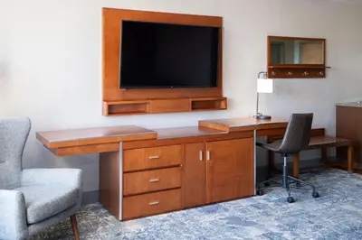 a room with a desk with a television and a chair at Four Points by Sheraton Victoria Gateway in Victoria