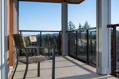a balcony with a chair and a view of the mountains at Four Points by Sheraton Victoria Gateway in Victoria
