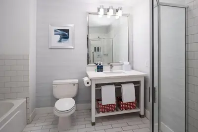 a bathroom with a toilet and a sink and a mirror at Four Points by Sheraton Victoria Gateway in Victoria
