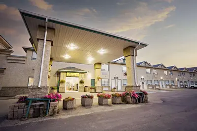 a building with potted plants in front of it at Super 8 by Wyndham Drayton Valley in Drayton Valley