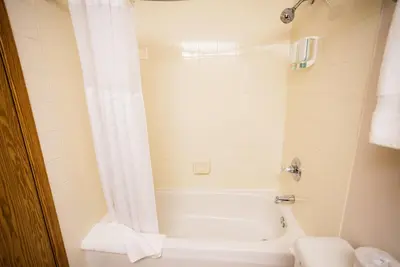 a bathroom with a tub and a toilet and a shower at Super 8 by Wyndham Drayton Valley in Drayton Valley