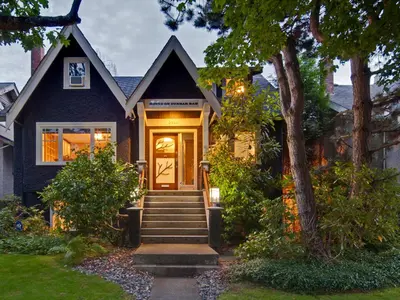 a blue house with a front door and stairs at House On Dunbar B&B in Vancouver