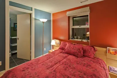 a bedroom with a red bed and a window at House On Dunbar B&B in Vancouver