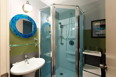 a bathroom with a glass shower and a sink at House On Dunbar B&B in Vancouver