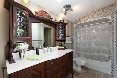 a bathroom with a sink and a toilet and a mirror at House On Dunbar B&B in Vancouver