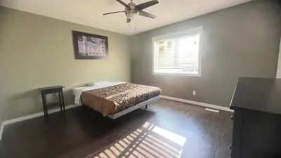 a bedroom with a bed and a ceiling fan at Monthly Accommodation Edmonton Londondery, Pilot Sound, McConachie Area in Edmonton