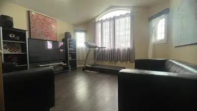 a living room with a couch and a television at Monthly Accommodation Edmonton Londondery, Pilot Sound, McConachie Area in Edmonton
