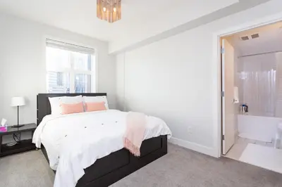 a white bedroom with a bed and a bath tub at ELEMENT ON FIRST by Manna in Calgary
