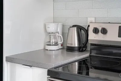 a kitchen counter with a coffee maker and a blender at ELEMENT ON FIRST by Manna in Calgary