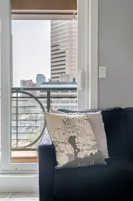 a couch with a pillow in a room with a window at ELEMENT ON FIRST by Manna in Calgary