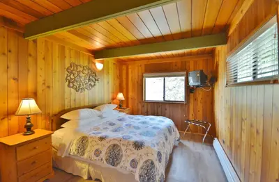 a bedroom with a bed in a wooden room at Pender Harbour Resort & Marina in Garden Bay