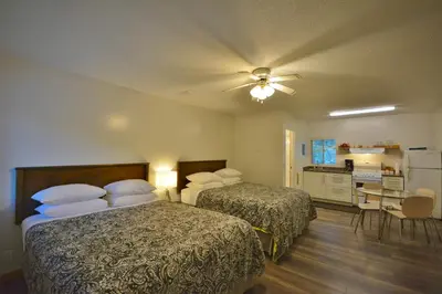 a hotel room with two beds and a kitchen at Pender Harbour Resort & Marina in Garden Bay