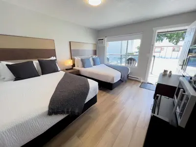 a hotel room with two beds and a television at Oceanside Villas in Sechelt