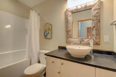 a bathroom with a sink and a toilet and a mirror at Newfie Seaside Retreat in Port Renfrew
