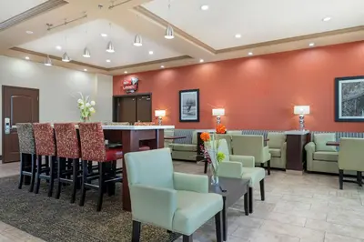 a waiting room with a bar and chairs at Best Western Pacific Inn in Vernon