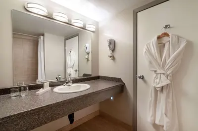 a bathroom with a sink and a mirror at Ramada by Wyndham Northern Grand Hotel & Conference Centre in Fort Saint John
