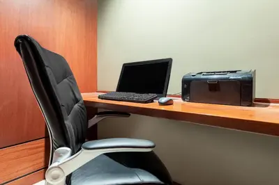 a desk with a laptop computer and a printer at Ramada by Wyndham Northern Grand Hotel & Conference Centre in Fort Saint John