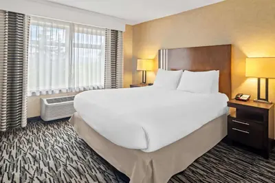 a large white bed in a hotel room at Best Western Plus Pitt Meadows Inn & Suites in Pitt Meadows