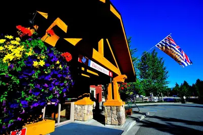 a building with a flag and flowers in front of it at Pemberton Valley Lodge in Pemberton