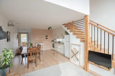 a kitchen and dining room with a staircase in a house at Le Chalet Waterfront Retreat in Ucluelet
