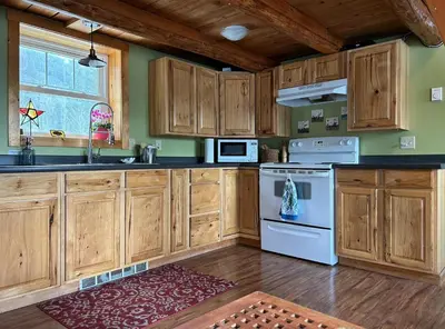 a kitchen with wooden cabinets and a white stove top oven at Morning Star Cabin in Nelson